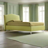 Green designer storage bed in green room with green curtains and rug